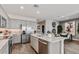 Modern kitchen features a large island with a sink, stainless steel appliances, gray cabinets, and access to the dining area at 4927 S 106Th Ave, Tolleson, AZ 85353