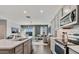 Well-lit kitchen features stainless steel appliances, gray cabinetry, an island, and an open layout to the living room at 4927 S 106Th Ave, Tolleson, AZ 85353