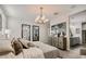 Bright main bedroom boasts decorative lighting, dual mirrors, art display over cabinet, and attached ensuite bath at 4927 S 106Th Ave, Tolleson, AZ 85353