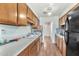 Galley-style kitchen with wood cabinets, double sink and appliances including a stove and refrigerator at 5032 N 78Th St, Scottsdale, AZ 85250