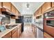 Galley-style kitchen with wood cabinets and appliances including a stove and refrigerator at 5032 N 78Th St, Scottsdale, AZ 85250