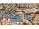 Aerial view showcasing tennis and pickleball courts near parking lots and a large community center with a pond at 540 Leisure World --, Mesa, AZ 85206