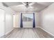 Neutral bedroom with wood-look floors, ceiling fan, curtains, and natural light at 540 Leisure World --, Mesa, AZ 85206