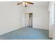 Bedroom with plush blue carpet, ceiling fan, and a mirrored closet at 5867 W Cochise Dr, Glendale, AZ 85302