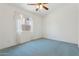Bedroom with blue carpet, a ceiling fan, and a large window at 5867 W Cochise Dr, Glendale, AZ 85302
