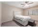 Neutral bedroom featuring a padded platform bed, soft carpet and a modern ceiling fan at 6618 S 54Th Ln, Laveen, AZ 85339