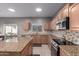 Spacious kitchen with granite counters, an island, tile backsplash, and modern appliances at 6618 S 54Th Ln, Laveen, AZ 85339