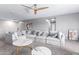 Cozy living room featuring a large sectional sofa, marble coffee tables, and modern ceiling fan at 6618 S 54Th Ln, Laveen, AZ 85339