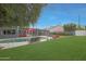 Inviting backyard showcasing a private pool, comfortable seating areas with red umbrellas, and ample green space at 6746 E Monterosa St, Scottsdale, AZ 85251