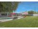 Inviting backyard showcasing a private pool, comfortable seating areas with red umbrellas, and ample green space at 6746 E Monterosa St, Scottsdale, AZ 85251