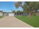 Contemporary gray home featuring a large tree, modern garage door, and well-maintained green lawn at 6746 E Monterosa St, Scottsdale, AZ 85251