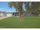 Contemporary gray home featuring a large tree, modern garage door, and well-maintained green lawn at 6746 E Monterosa St, Scottsdale, AZ 85251