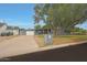 Modern gray home with well-kept lawn, a large shade tree, contemporary garage door, and an inviting driveway at 6746 E Monterosa St, Scottsdale, AZ 85251