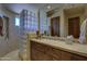 Bathroom featuring glass block wall shower, single sink vanity with storage, and a tile floor at 7373 E Clubhouse Dr # 24, Scottsdale, AZ 85266