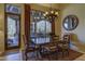Charming dining room featuring a wooden table, decorative chandelier, and picturesque view of the outdoor pool area at 7373 E Clubhouse Dr # 24, Scottsdale, AZ 85266