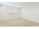 This bedroom has neutral carpet, a window and a ceiling light at 7422 W Buckhorn Trl, Peoria, AZ 85383