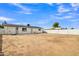 Large dirt backyard awaiting customization and landscaping, with access door to the home at 7526 E Drummer Ave, Mesa, AZ 85208