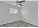 Well-lit bedroom featuring new gray luxury vinyl flooring, a window and a ceiling fan at 7526 E Drummer Ave, Mesa, AZ 85208