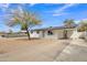 Attractive single-story house featuring a white exterior, long driveway and desert landscaping at 7526 E Drummer Ave, Mesa, AZ 85208