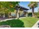 Charming backyard with an outdoor kitchen, covered patio, manicured lawn, and mature trees at 7725 N Via De Fonda --, Scottsdale, AZ 85258