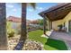 Private backyard with an outdoor kitchen, rock feature, patio, and mature palm trees at 7725 N Via De Fonda --, Scottsdale, AZ 85258