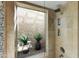 This walk-in shower features a unique rock accent wall and a green garden view at 7725 N Via De Fonda --, Scottsdale, AZ 85258