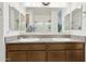 Bathroom featuring double sinks with granite countertops, wood cabinets, and large mirrors for a spacious feel at 786 W Palo Verde W Dr, Casa Grande, AZ 85122