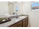 Well-lit bathroom featuring a vanity with a granite countertop, dark wood cabinets, and a view to the outside at 786 W Palo Verde W Dr, Casa Grande, AZ 85122