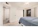 A bedroom with an ensuite bathroom, a ceiling fan, and neutral-colored carpet at 8155 E Roosevelt St # 204, Scottsdale, AZ 85257