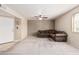Spacious living room offers neutral carpet, ceiling fan, and a comfortable sectional sofa at 8155 E Roosevelt St # 204, Scottsdale, AZ 85257