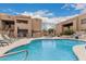 Community pool features lounge chairs and outdoor tables with desert landscaping at 8155 E Roosevelt St # 204, Scottsdale, AZ 85257