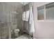 Modern shower with glass door, gray tile, pebble floor, and a towel robe at 8238 E San Miguel Ave, Scottsdale, AZ 85250
