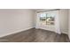 A bright bedroom featuring wood-look floors and a large window with neutral curtains at 8238 E San Miguel Ave, Scottsdale, AZ 85250
