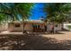 Backyard view featuring the home's exterior, a spacious yard with desert landscaping, and a covered patio at 8238 E San Miguel Ave, Scottsdale, AZ 85250