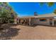 Rear exterior view highlighting the large backyard with desert landscaping, covered patio, and neutral-toned home at 8238 E San Miguel Ave, Scottsdale, AZ 85250