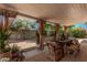 Comfortable covered patio with a dining table and wicker chairs, perfect for outdoor dining and relaxation at 8238 E San Miguel Ave, Scottsdale, AZ 85250