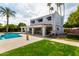 Backyard features a pool, patio, lush lawn, and palm trees, creating a private oasis for relaxation and recreation at 8438 E Stella Ln, Scottsdale, AZ 85250