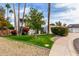 Landscaped front yard featuring lush greenery, a variety of flowers, and mature trees adding character and beauty to the property at 8438 E Stella Ln, Scottsdale, AZ 85250