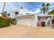 Side view of a home featuring a spacious two-car garage and a covered carport, blending functionality with classic design at 8438 E Stella Ln, Scottsdale, AZ 85250