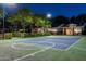 Full basketball and tennis court illuminated at night, perfect for sports activities and entertaining guests at 8602 E Gary Rd, Scottsdale, AZ 85260