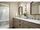 Bright bathroom featuring double sinks, marble countertops, decorative mirrors, and a walk-in shower at 8602 E Gary Rd, Scottsdale, AZ 85260