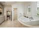 Bright bathroom featuring a freestanding tub, glass shower, and large windows with plantation shutters at 8602 E Gary Rd, Scottsdale, AZ 85260