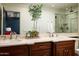 Bright bathroom featuring double sinks, marble countertops, decorative mirror and a walk-in shower at 8602 E Gary Rd, Scottsdale, AZ 85260