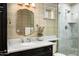 Elegant bathroom with marble countertops, decorative mirror, walk-in shower, and neutral wallpaper at 8602 E Gary Rd, Scottsdale, AZ 85260