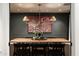 Chic dining room with a long wooden table, sophisticated lighting, and dark paneled walls at 8602 E Gary Rd, Scottsdale, AZ 85260