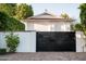 View of a black metal gate that secures the property, framed by a white wall at 8602 E Gary Rd, Scottsdale, AZ 85260