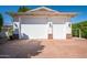 Spacious two car garage with white doors, brick detail, and ample lighting at 8602 E Gary Rd, Scottsdale, AZ 85260