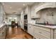 Elegant kitchen with marble countertops, stainless steel appliances, and custom cabinetry with a view to the breakfast nook at 8602 E Gary Rd, Scottsdale, AZ 85260