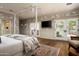 Bright main bedroom with canopy bed, TV, hardwood flooring, and access to a private outdoor space at 8602 E Gary Rd, Scottsdale, AZ 85260