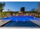 Inviting pool with a waterfall, fire bowls, and a TV for ultimate relaxation and entertainment at 8602 E Gary Rd, Scottsdale, AZ 85260